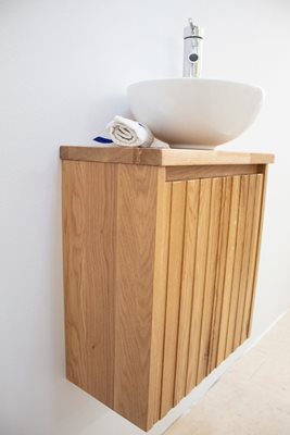 ארון אמבטיה תלוי רוחב 47 ס"מ בעומק 24 ס"מ עשוי מעץ מלא אלון מבוקע עם משטח עץ מלא להנחת כיור מונח דגם צוקר