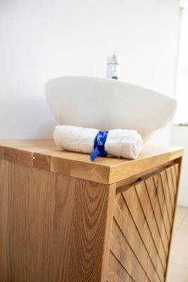 ארון אמבטיה תלוי רוחב 55 ס"מ בעומק 33 ס"מ עשוי מעץ מלא אלון מבוקע עם משטח עץ מלא להנחת כיור מונח דגם קומו