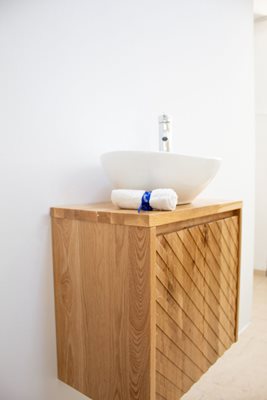 ארון אמבטיה תלוי רוחב 55 ס"מ בעומק 33 ס"מ עשוי מעץ מלא אלון מבוקע עם משטח עץ מלא להנחת כיור מונח דגם קומו