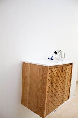 ארון אמבטיה תלוי רוחב 55 ס"מ בעומק 33 ס"מ עשוי מעץ מלא אלון מבוקע עם כיור משטח חרס שקוע דגם הובז