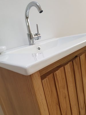 ארון אמבטיה תלוי רוחב 60 ס"מ בעומק 46 ס"מ עשוי מעץ מלא אלון מבוקע עם כיור משטח חרס שקוע דגם ג'אסבר